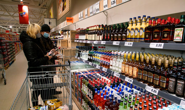 Посетители у полки с алкогольной продукцией в магазине Посетители у полки с алкогольной продукцией в магазине