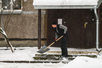 Мужчина убирает снег