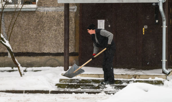Мужчина убирает снег Мужчина убирает снег
