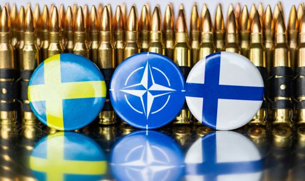 Флаги Швеции, НАТО и Финляндии на фоне патронов