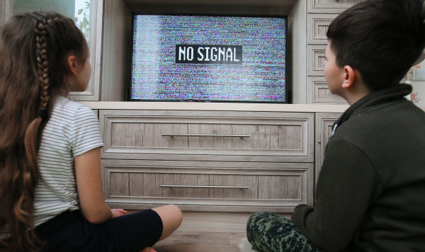 Дети у телевизора с изображением эфирного шума