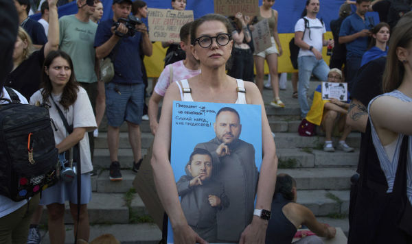 Протестующая держит в руках плакат с изображением президента Владимира Зеленского и главы Офиса Андрея Ермака Протестующая держит в руках плакат с изображением президента Владимира Зеленского и главы Офиса Андрея Ермака