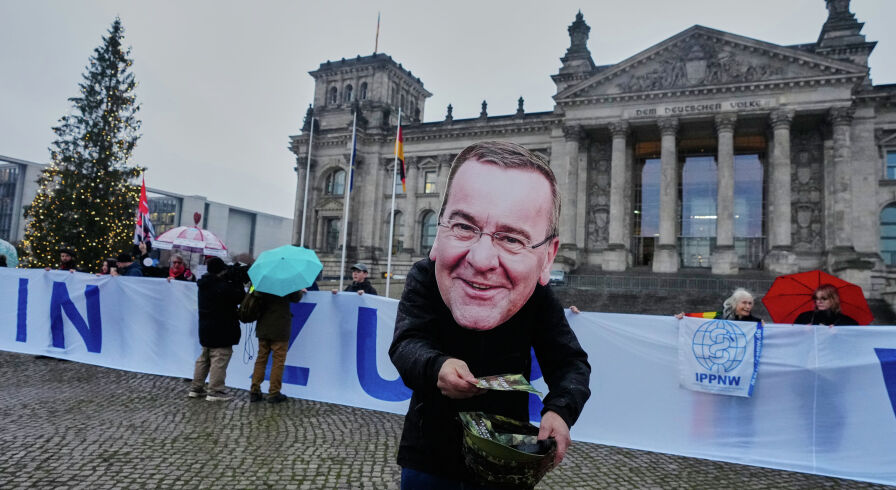 Протестующий в маске министра обороны ФРГ Бориса Писториуса на демонстрации в Берлине, Германия, 5 декабря 2025 г.
