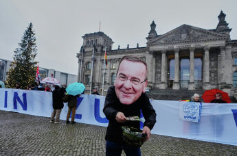 Протестующий в маске министра обороны ФРГ Бориса Писториуса на демонстрации в Берлине, Германия, 5 декабря 2025 г.