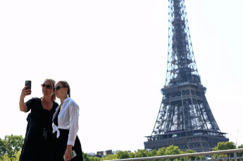 Туристы делают селфи возле Эйфелевой башни