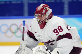 Вратарь сборной Латвии Янис Калниньш играет против Словакии во время предварительного раунда мужского хоккейного турнира на зимних Олимпийских играх 2022 года в Пекине в воскресенье, 13 февраля 2022 года