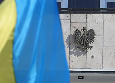 Государственный флаг Украины и герб Польши у посольства Польши в Киеве.