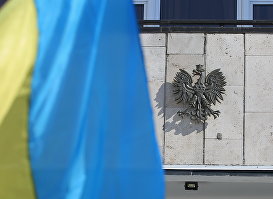 Государственный флаг Украины и герб Польши у посольства Польши в Киеве.